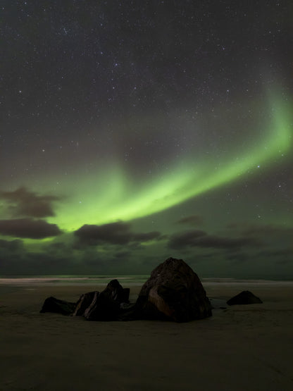 Rocas bajo la aurora boreal